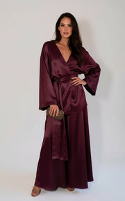 Woman wearing a burgundy silk kimono and wide-leg pants set