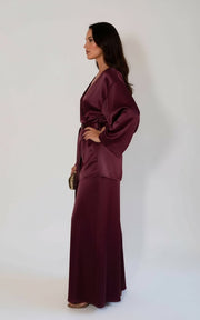 Woman wearing a burgundy silk kimono and wide-leg pants set